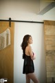 A woman standing in front of a wooden door.