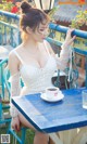 A woman sitting at a table with a cup of coffee.