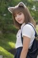 A young woman wearing a cat ears headband and a backpack.